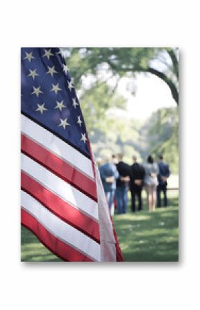 American flag flying with red, white, and blue flower tribute during Memorial Day ceremony