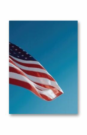 intricately draped american flag gently flutters against clear blue sky