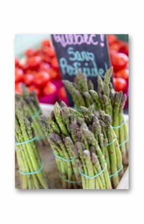 Bundles of fresh asparagus are displayed for sale at Marche Jean Talon farmer's market in the Montreal, Quebec, Canada. The vegetables are tied with rubber bands and ready for purchase.
