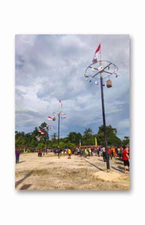 Indonesian People Gathering for Panjat Pinang Tradition on Independence Day. A festive crowd gathers for the traditional Panjat Pinang competition to celebrate Indonesia's Independence Day.