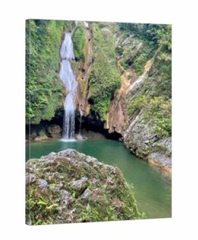 Waterfall cascading into the clear jungle pool surrounded by lush green forest in central Cuba, elevated view