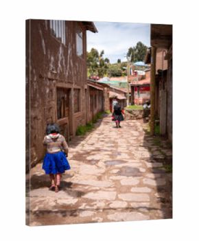 Andean girl and woman walking in a village on Taquile Island