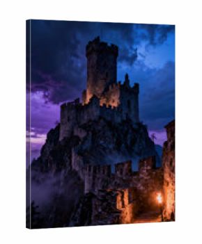 A grand castle stands on a rocky peak, illuminated by warm lights against a backdrop of dark, swirling clouds. A torch lights the pathway, enhancing the mystical atmosphere of the scene
