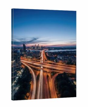 Aerial Long Exposure of Highway Interchange at Dusk With City Skyline View