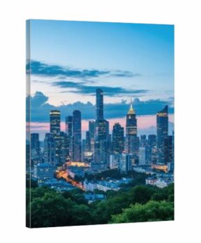 Illuminated cityscape view with modern tall buildings and green trees at night