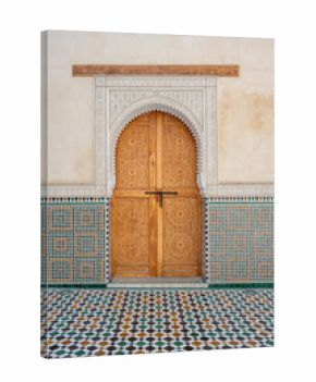Highly decorated doorway framed by intricate zellige tiles and a patterned floor inside the Mausoleum of Moulay Ismail in Meknes, Morocco. The ornate craftsmanship showcases traditional Moroccan art