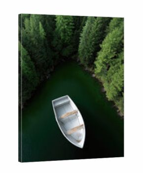 White rowboat floats on dark green forest lake surrounded by dense pine trees, tranquil and peaceful nature scene