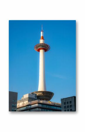 The iconic Kyoto Tower stands tall against a clear blue sky, showcasing its modern design and panoramic observation deck in the heart of Kyoto, Japan.