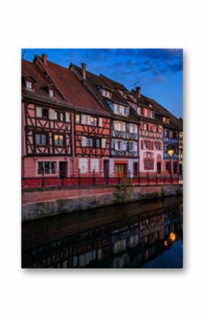 Half timbered houses by canals of Little Venice in Colmar, France at sunset