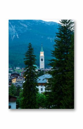 A view of the iconic church tower in the heart of Cortina d'Ampezzo. The architectural beauty of the tower stands tall against the backdrop of the surrounding Alpine scenery