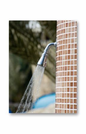 Shower on the beach. Closeup of outdoor shower head. Outdoor pool shower. Water running from poolside shower sprinkler