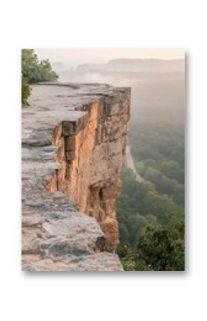 Rock Formation Emerging from Fog above Valley at Sunrise