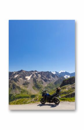 Motorcycle parked on a mountain road overlooking the French Alps