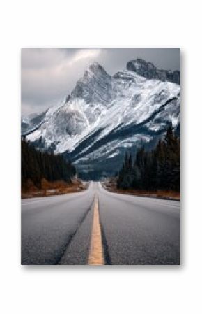 Road Leading to Majestic Mountains Under Clear Blue Sky in Early Morning Light.