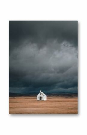 Black and White Chapel Under Dramatic Cloudy Sky in Isolated Landscape at Dusk.
