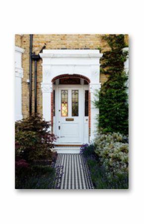White door with stained glass window and black and white tiled pathway leading to entrance of London house