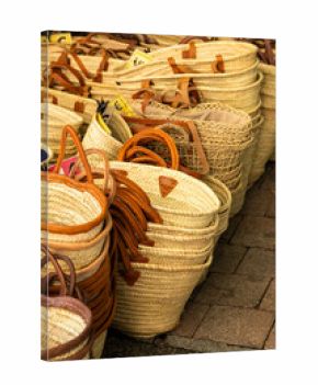 Wicker baskets with leather handles creating a pattern in a french market in Nyons
