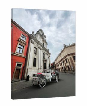 Elegant white horse-drawn carriage in a historic European city street view in Krakow, Poland.