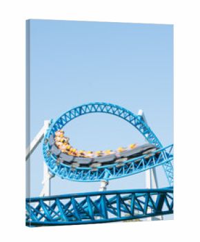 Roller coaster Ride against blue sky. Roller coaster in the amusement park. Cheerful entertainments in park of attractions