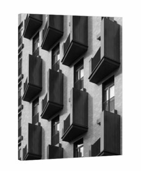 Black and white photo of a modern residential building facade with repeating dark balconies creating