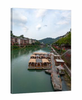 Xuan'en County boats wait on a calm river near town and hills in Hubei Province, China.