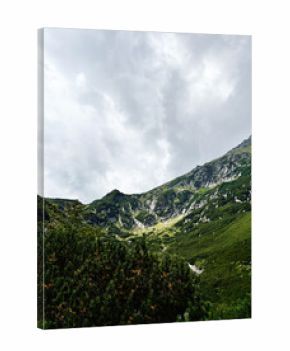 Mountain valley near Zakopane Poland with green slopes, rocky ridges, and moody clouds