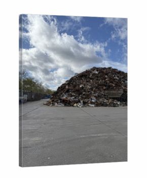Scrap metal awaits recycling under a cloudy sky