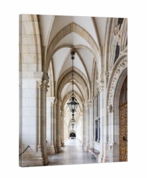Vertical view of the Gothic Revival 1883 City Hall (Wiener Rathaus) arcade, with its series of hanging lights, a carved wooden door and a stone colonnade, Vienna, Austria