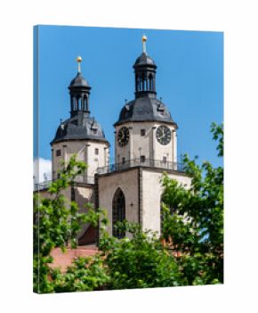 Towers of St. Mary’s Church in Wittenberg peeking out from behind trees. Historic Reformation church linked to Martin Luther.