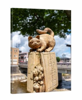 Wooden cat statue by Miyagawa River in Takayama, Japan