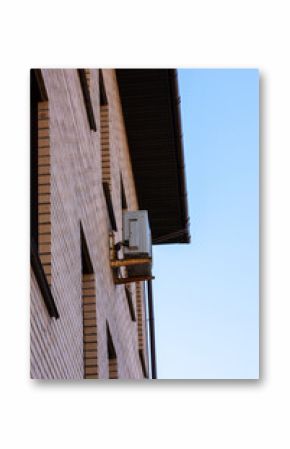 A brick building has an air conditioner attached to its side