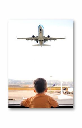 Traveler child. Tourist boy is excitedly waiting for his flight. Kid watching planes taking off from airport window.