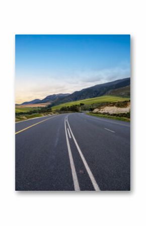 Beautiful winding country road with golden wheat fields and rolling green hills in the Overberg region of Western Cape, South Africa