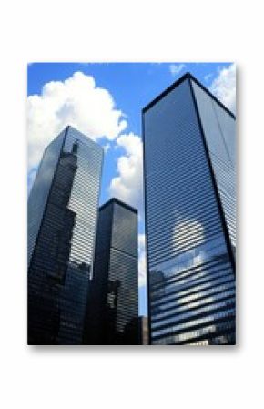 Skyscrapers shine under a bright blue sky with fluffy clouds in an urban setting during the afternoon