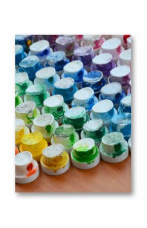 A pattern from a many nozzles from a paint sprayer for drawing graffiti, smeared into different colors. The plastic caps are arranged in many rows forming the color of the rainbow