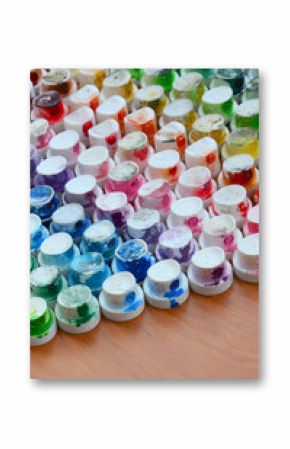 A pattern from a many nozzles from a paint sprayer for drawing graffiti, smeared into different colors. The plastic caps are arranged in many rows forming the color of the rainbow