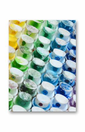 A pattern from a many nozzles from a paint sprayer for drawing graffiti, smeared into different colors. The plastic caps are arranged in many rows forming the color of the rainbow