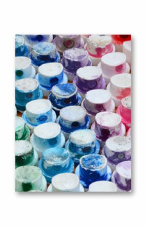 A pattern from a many nozzles from a paint sprayer for drawing graffiti, smeared into different colors. The plastic caps are arranged in many rows forming the color of the rainbow