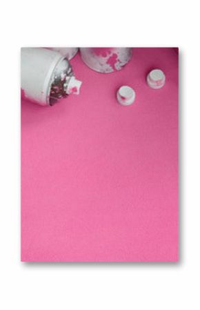 Some used pink aerosol spray cans and nozzles with paint drips lies on a blanket of soft and furry light pink fleece fabric. Classic female design color. Graffiti hooliganism concept