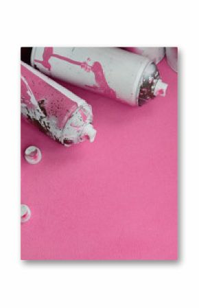 Some used pink aerosol spray cans and nozzles with paint drips lies on a blanket of soft and furry light pink fleece fabric. Classic female design color. Graffiti hooliganism concept