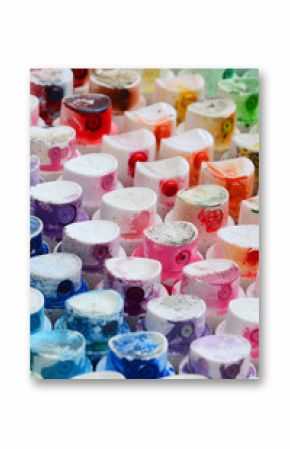 A pattern from a many nozzles from a paint sprayer for drawing graffiti, smeared into different colors. The plastic caps are arranged in many rows forming the color of the rainbow