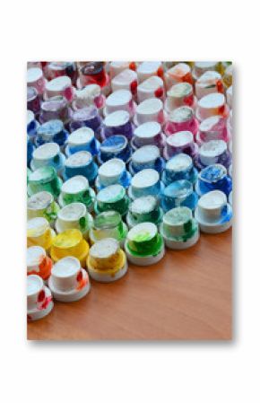 A pattern from a many nozzles from a paint sprayer for drawing graffiti, smeared into different colors. The plastic caps are arranged in many rows forming the color of the rainbow