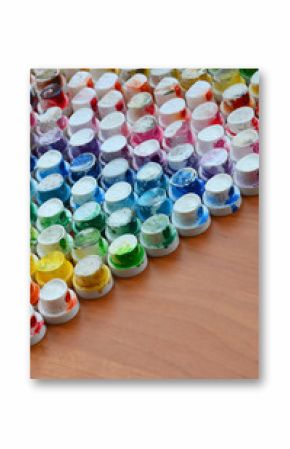 A pattern from a many nozzles from a paint sprayer for drawing graffiti, smeared into different colors. The plastic caps are arranged in many rows forming the color of the rainbow