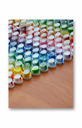 A pattern from a many nozzles from a paint sprayer for drawing graffiti, smeared into different colors. The plastic caps are arranged in many rows forming the color of the rainbow