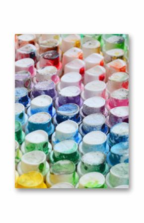A pattern from a many nozzles from a paint sprayer for drawing graffiti, smeared into different colors. The plastic caps are arranged in many rows forming the color of the rainbow