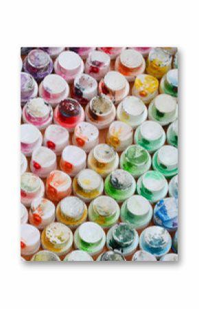 A pattern from a many nozzles from a paint sprayer for drawing graffiti, smeared into different colors. The plastic caps are arranged in many rows forming the color of the rainbow