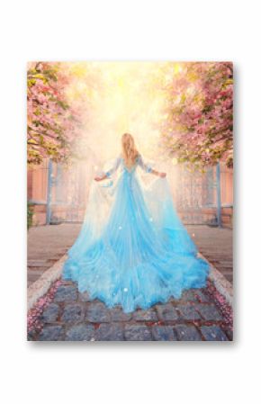 Art photo fantasy woman princess goes to meet light sun along spring street. Pink flowers sakura tree outdoor. Blue lush fairy dress, long train. Silhouette girl goddess, back view. Queen blond hair