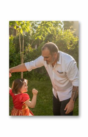 Father And Daughter With Down Syndrome Dancing Outdoors.