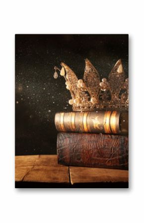 low key image of beautiful queen/king crown on old books. fantasy medieval period. Selective focus.