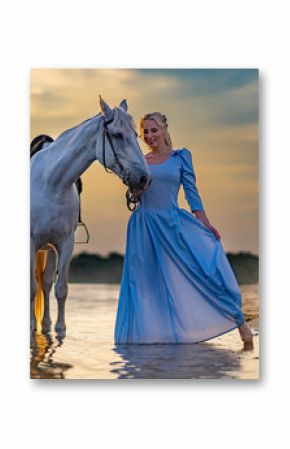 blonde with a horse near the water at sunset